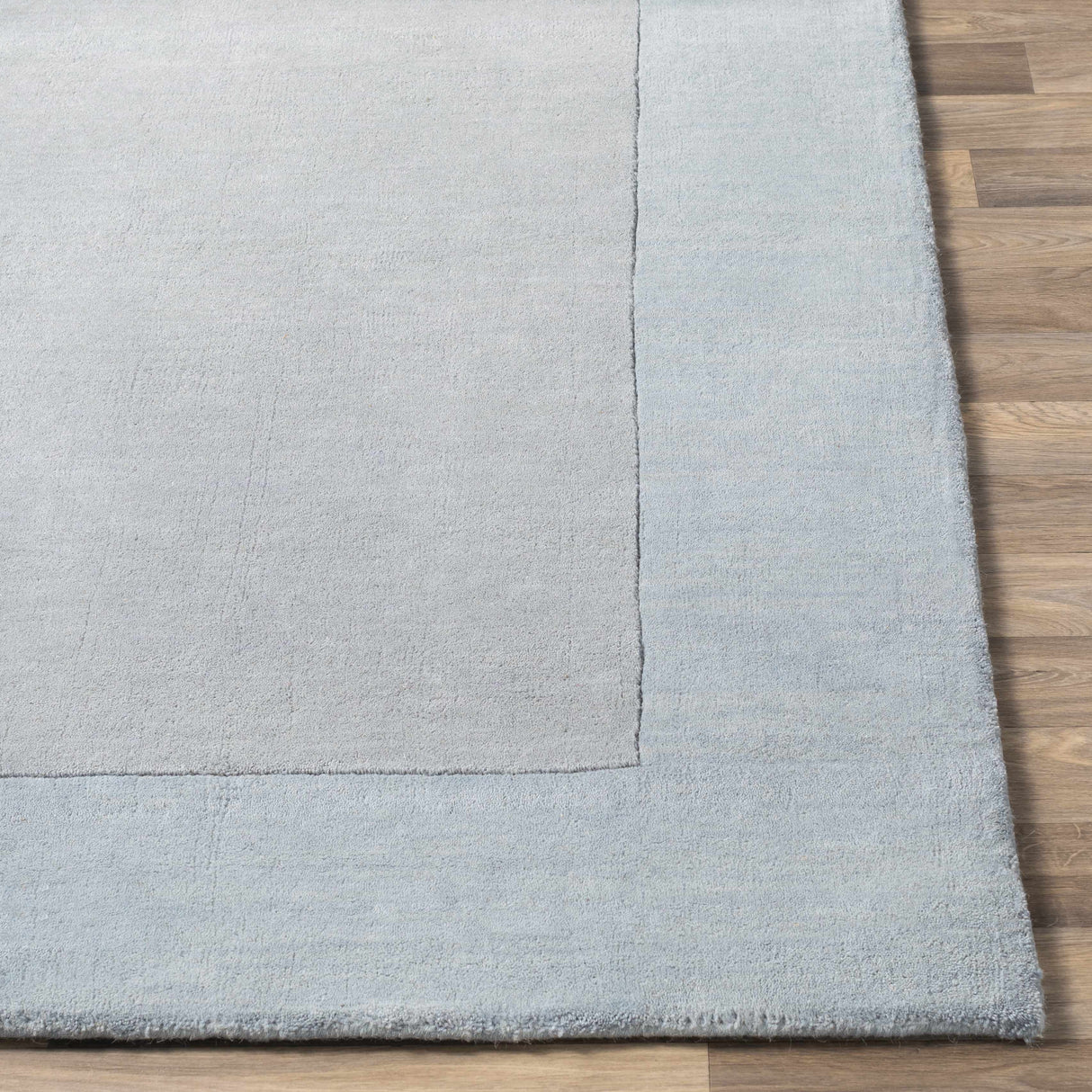 Arkabutla Solid Blue Bordered Wool Rug